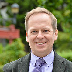 Profile of a mature man in a suit and tie smiling