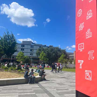 Groups of people in a city walking about and sitting down.