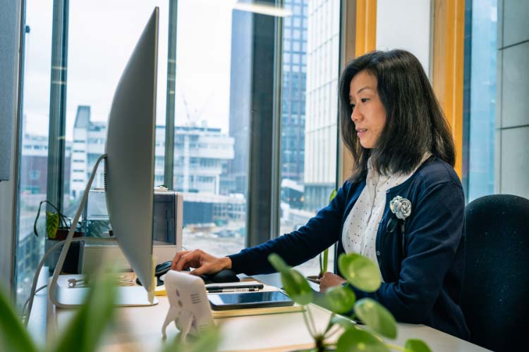 A researcher at the Manchester Institute of Biotechnology sat at her desktop next to a window.